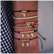 Red string bracelet with boy and heart charms